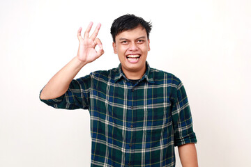 Naklejka premium Young asian man showing okay hand gesture with happy expression