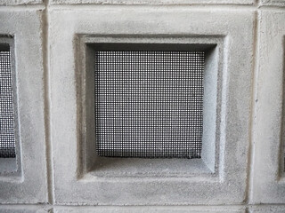 Ventilated block panel with safety net installed on a concrete wall.