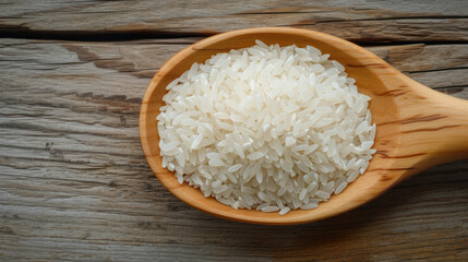 Rice pile in wooden spoon isolated on wood table background.