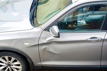 car door with large dent damage after road collision, view from above. Car body side damage,...
