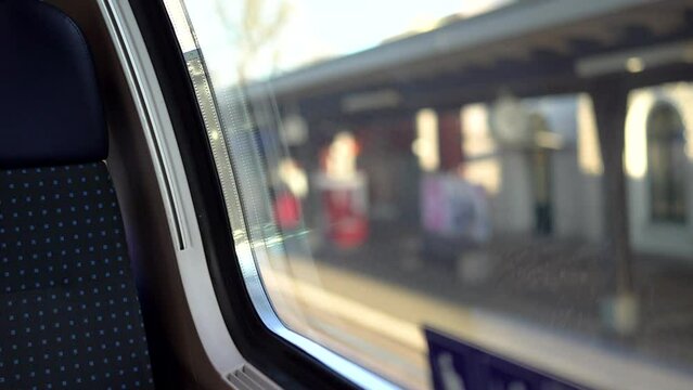 First person view from train window on train entering blurry station