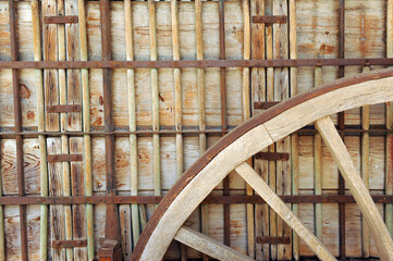 Primer plano de la rueda de un viejo carro agrícola de madera y refuerzos de hierro usado en la...