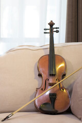 Violin and bow resting on the sofa