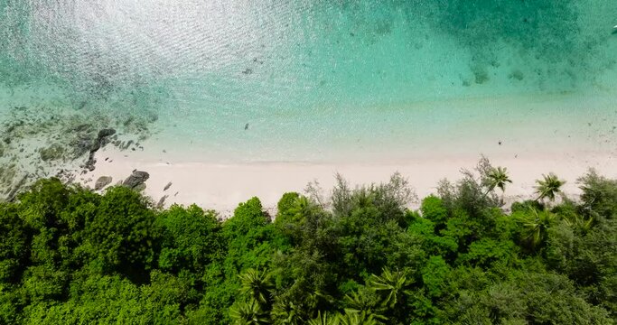 Top view of coastline with white sand beach and turquoise clear water with sun reflection. Romblon Island. Romblon, Philippines.