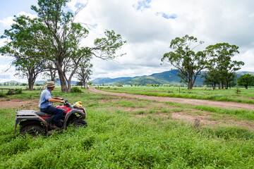 farmer on four wheeler riding through farm paddock