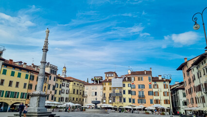 Fototapeta premium Colorful houses lining up on idyllic Piazza San Giacomo (Piazza Giacomo Matteotti or Mercato Nuovo) in city center of Udine, Friuli Venezia Giulia, Italy, Europe. Column with religious statue on top