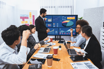 Businessman presenting data analysis dashboard display on TV screen in modern meeting for marketing...