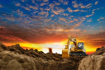 Crawler excavator with bucket lift up are digging the soil in the construction site on the sunset background - obrazy, fototapety, plakaty