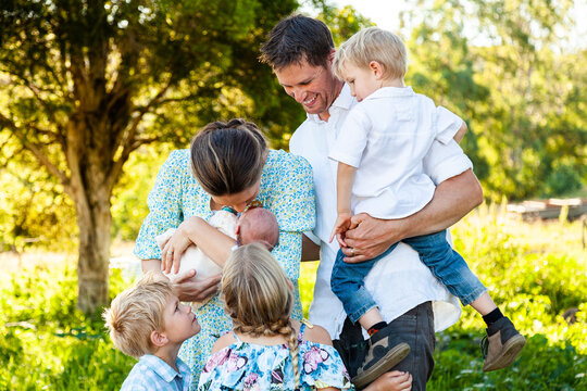 Mother and father with four children all looking at newborn sister