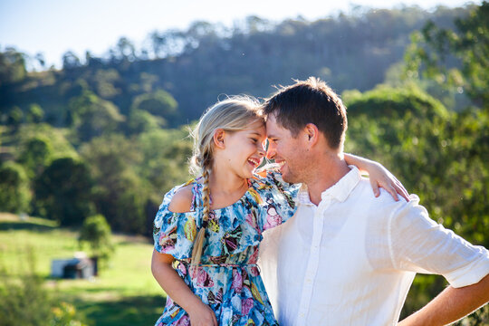 Intimacy or father and daughter looking at one another smiling outside on farm