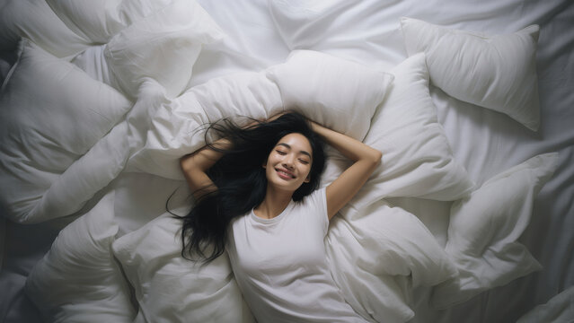 As Asian woman, She lies comfortably on a white, plush bed and pillow. Serenity in Smiles, Witness the tranquil happiness of a young woman, her eyes radiating joy. Generative AI.