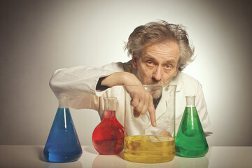 Older crazy chemist preparing a chemical experiment with some liquids
