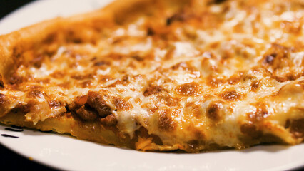 Close up of classic baked bean pizza slices on a plate.