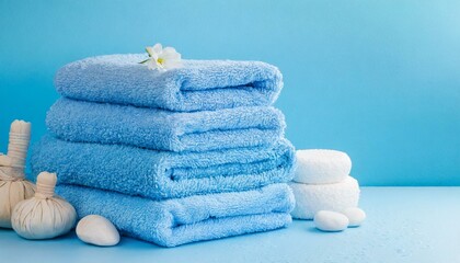 Fototapeta na wymiar Light blue spa towels pile bath towels lying in a stack on light blue peaceful