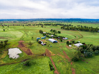 Distant homestead and other farm buildings in green home paddock