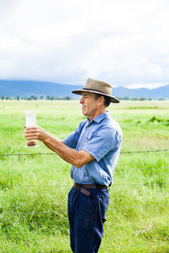 Farmer checking rain in bureau of meteorology rain gauge