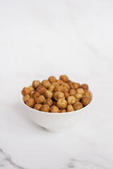 Almonds in a white bowl on a marble table