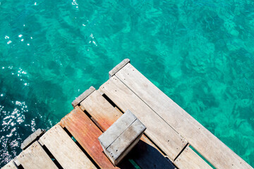 Abstract image of the contrast between the turquoise water and the wooden pier at Praia do...