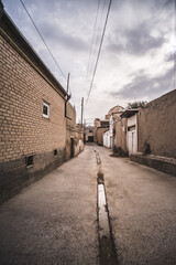 Ancient streets with buildings and houses in the ancient city of Bukhara in Uzbekistan on a cloudy summer day