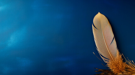 a feather resting on a plant against a blue wall