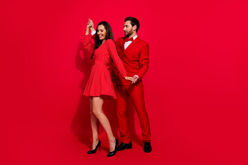 Full body photo of attractive young couple dancing have fun valentine day wear trendy elegant clothes isolated on red color background