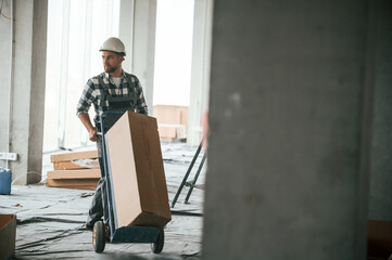 Repairman in uniform is in the unfinished building