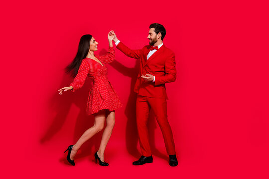 Full length photo of stunning young couple cool dance have fun valentine day wear trendy elegant garment isolated on red color background