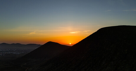 Spectacular sun set image over Volcan Calderon Hondo volcanic crater silhouetted against the setting sun and skyscape near Corralejo, Fuerteventura, Canary Islands, Spain