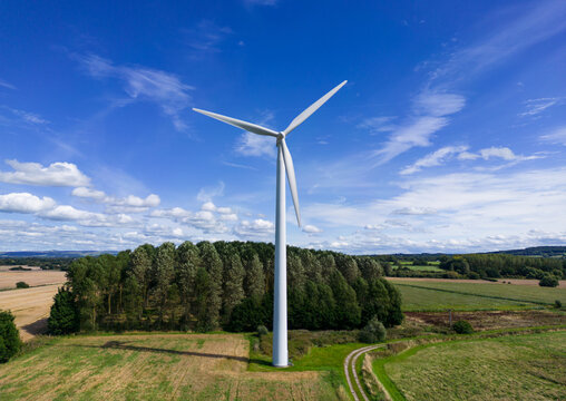 Aerial mid-level image of a small rural wind farm with wind turbines in the English countryside