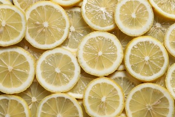 Fototapeta premium Slices of fresh lemons as background, top view