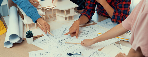 Skilled architect engineer team meeting pointing at blueprint while professional interior designer analysis and brainstorming about house structure. Creative design and teamwork concept. Burgeoning. - obrazy, fototapety, plakaty