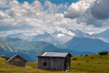 Old wooden cabins in the Stubai Alps and a scenic panoramic view of Zillertal Alps with Olperer...