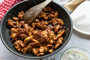 Homemade gyros, greek meat dish in a frying pan on kitchen table
