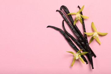 Vanilla pods and beautiful flowers on pink background, top view. Space for text
