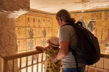 a tourist watching the sculptural details on the wall of the temple of the Tutankhamun king, Luxor,...