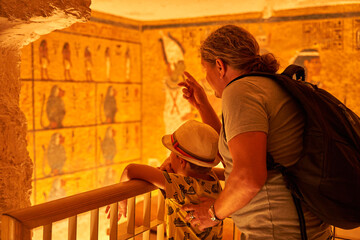 a tourist watching the sculptural details on the wall of the temple of the Tutankhamun king, Luxor,...