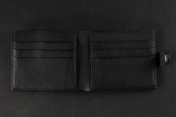 Black leather wallet business card holder on a black background.