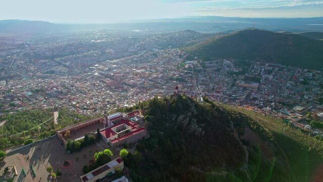 Captivating drone orbit around Zacatecas' Cerro de la Bufa, highlighting the lighthouse and offering breathtaking views of the city below