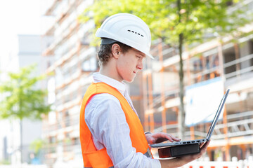 Engineer with helmet working outside new building