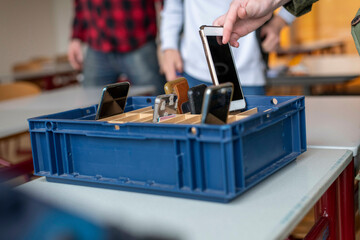 Young students collecting their phones after class 