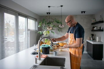 Nederland - Ui snijden. Koken op inductie. Man is in de keuken bezig met het maken van lasagnesaus. foto: Patricia Rehe / ANP / Hollandse Hoogte