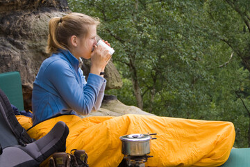 Frau trinkt Kaffee in einem Schlafsack, Camping, Trekking, Elbsandsteingebirge, Sachsen, Deutschland