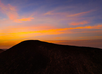 Spectacular sun set image over Volcan Calderon Hondo volcanic crater silhouetted against the setting sun and skyscape near Corralejo, Fuerteventura, Canary Islands, Spain