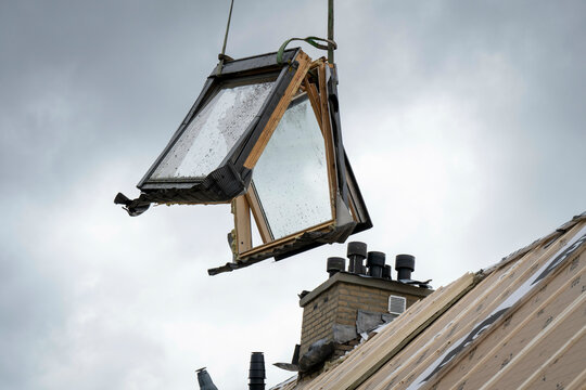 Windows being lifted into position over a new roof 