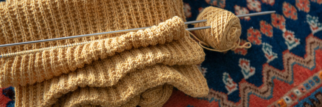 Close up of an Elderley lady knitting at her dining room table 