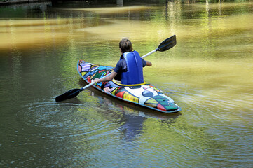 garoto praticando canoagem com canoa no lago, férias escolares 