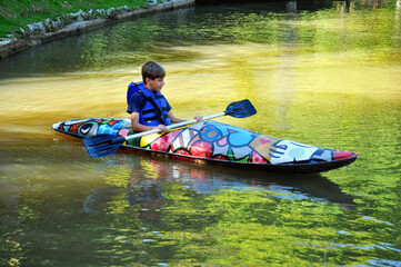 garoto praticando canoagem com canoa no lago, férias escolares 
