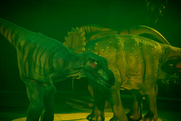 Green prehistoric dinosaur mannequin in mystical light.