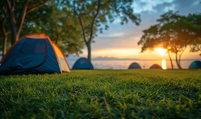 Selective focused on Lawn or green grass ground of camping ground near the sea beach. with camping tent in the background. - obrazy, fototapety, plakaty