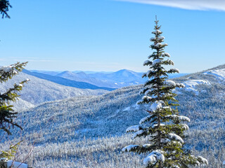 A snowy and winter landscape of the White Mountains of New Hampshire from the side of Mt....